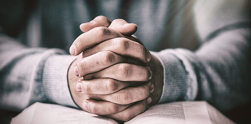 Betende Hände auf einer Bibel