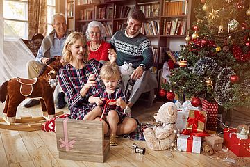 Familie mit Geschenken und Christbaum