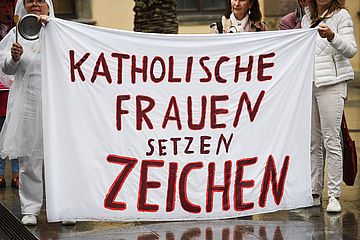 Frauen halten Banner mit der Aufschrift 