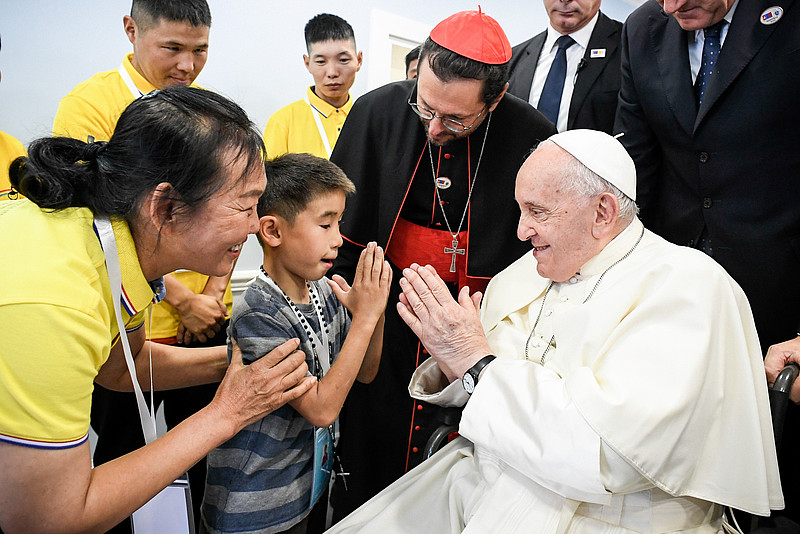 Papst Franziskus und ein Kind falten die Hände am 4. September 2023 bei der Einweihung des katholischen Sozialzentrums "Haus der Barmherzigkeit" in Ulan Bator (Mongolei).