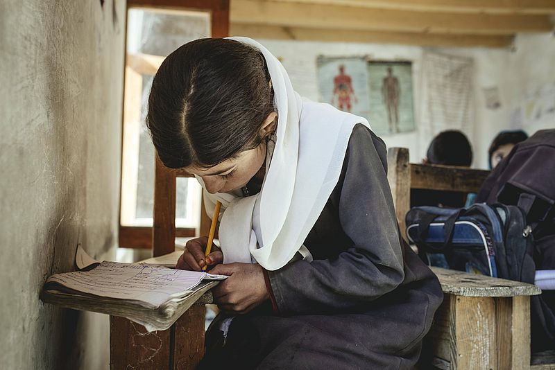 Mädchen schreibt in ein Schulheft