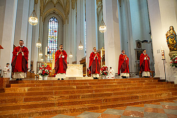 Fünf Männer im Priestergewand vor dem Altar