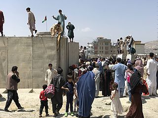 Am Kabuler Flughafen versuchen Menschen über die Mauern zu gelangen.