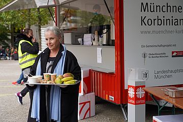 Schauspielerin Katerina Jcob hält ein Tablett in der Hand und steht vor der Münchner Korbinian-Küche