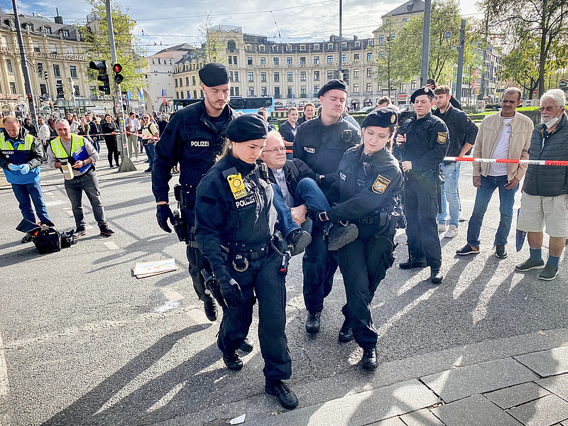 Polizisten tragen den Jesuitenpater Jörg Alt weg