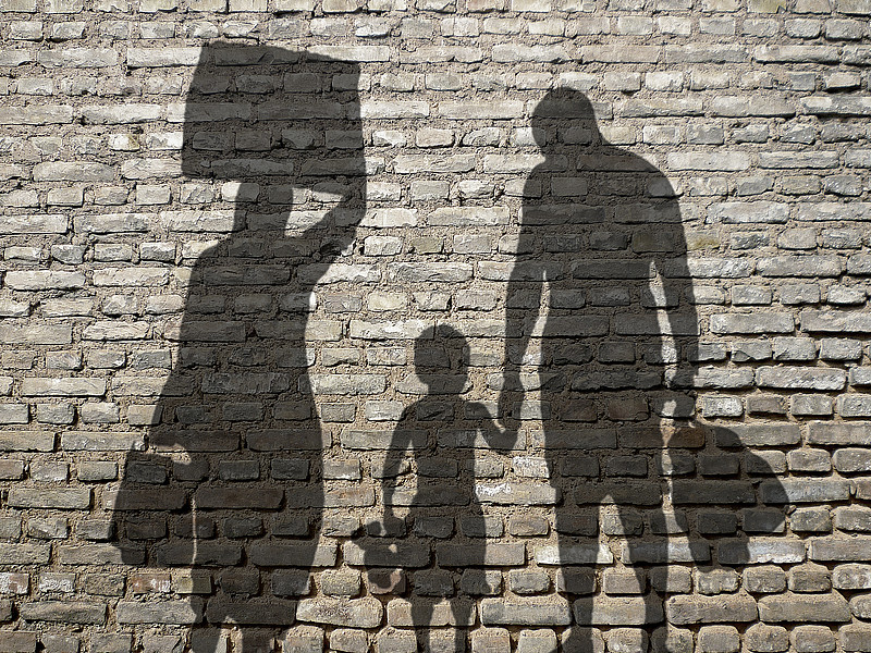 Schatten einer Familie auf Steinwand