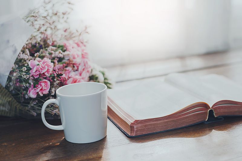 Bibel mit Tasse und Blumenstrauß