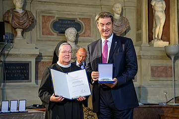 Schwester Benigna Sirl und Markus Söder halten Paipiere in den Händen