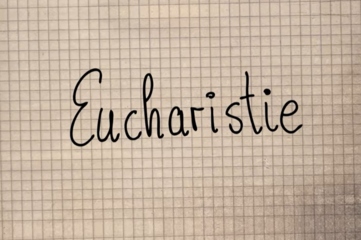 Eucharistie geschrieben auf kariertem Papier