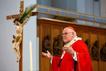 Kardinal Reinhard Marx mit Kruzifix im Hintergrund