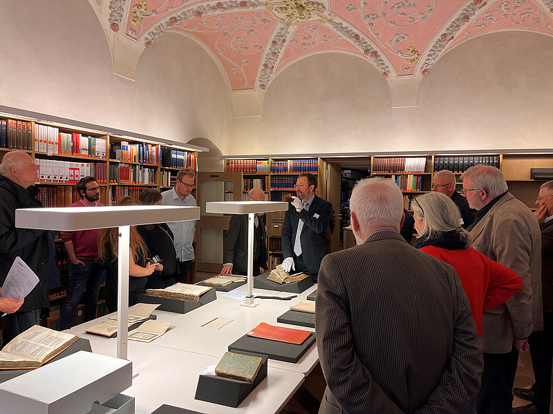 Roland Götz (Bildmitte) führt bei der großen Tagung zur Geschichte des Erzbistums München und Freising auch durch das Archiv der Erzdiözese. Um die historischen Dokumente zu schonen, trägt er weiße Handschuhe. 