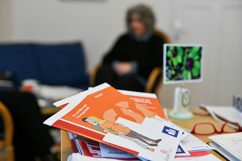 Broschüren liegen am 1. Dezember 2017 auf einem Tisch im Büro der Schwangerenberatungsstelle von Donum Vitae in Boppard. Im Hintergrund findet eine Beratung statt.