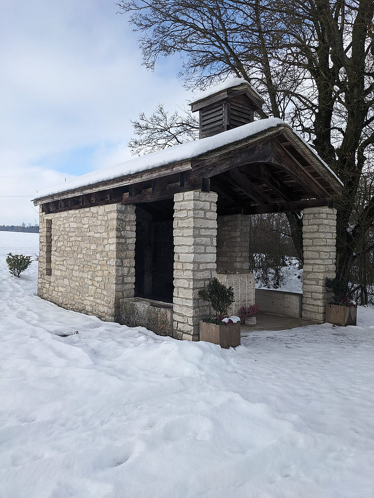 Blick von Außen auf die schneebedeckte Thaddäus-Kapelle