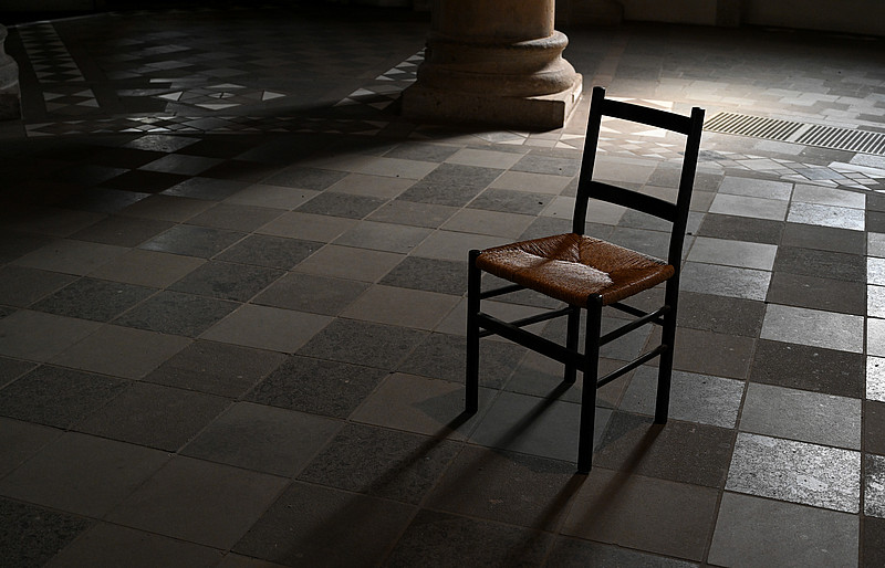 Ein Stuhl steht in einer dunklen Kirche
