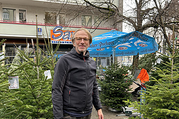 Christbaumverkäufer Werner Wesslau steht vor seinen Weihnachtsbäumen.