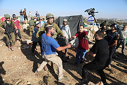 Palästinenser im Streit mit israelischen Siedlern im besetzten Westjordanland, dazu Soldaten.