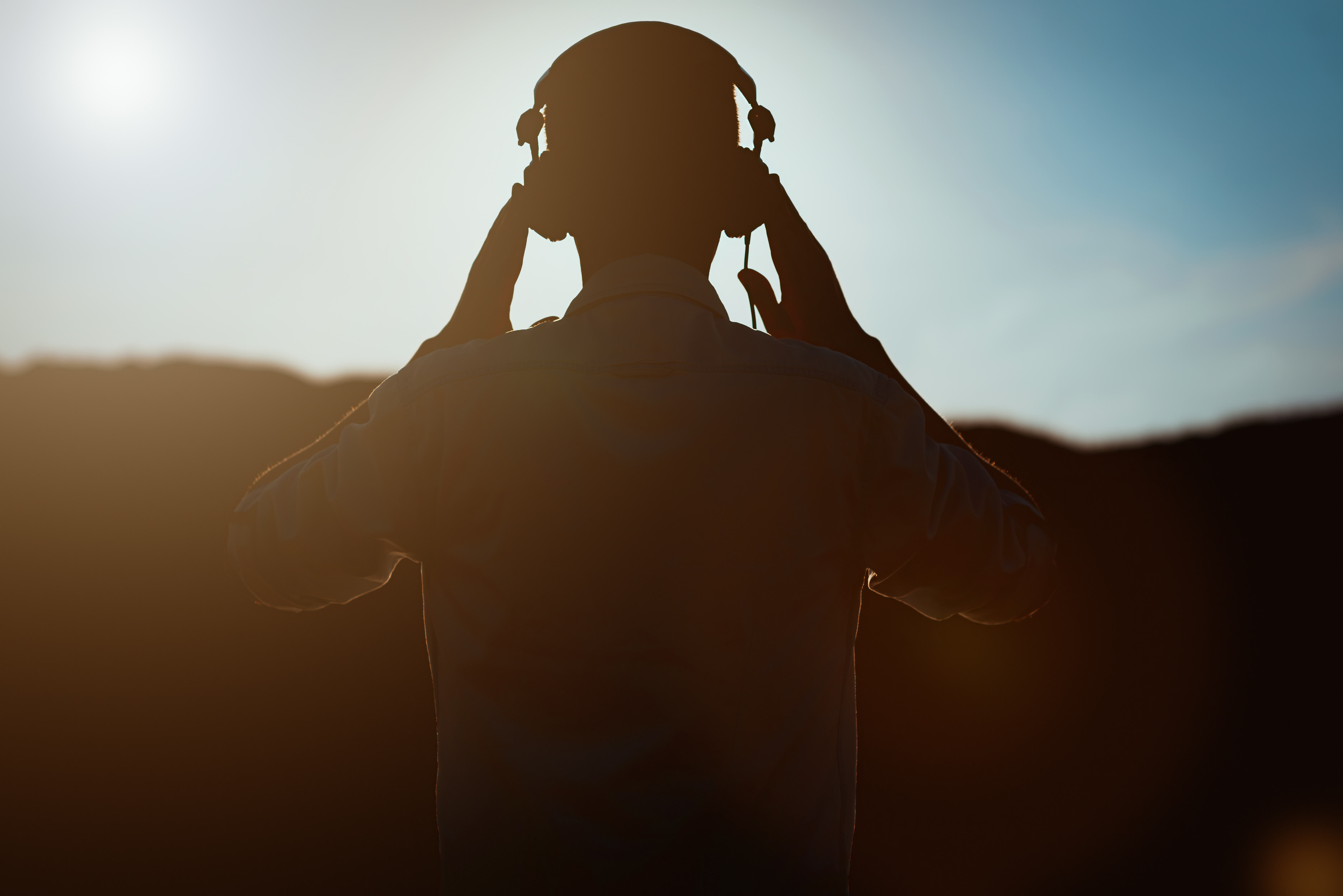 Фото силуэт DJ. Наушники небо. Man with Headphones from behind. Man in Headphone back view.